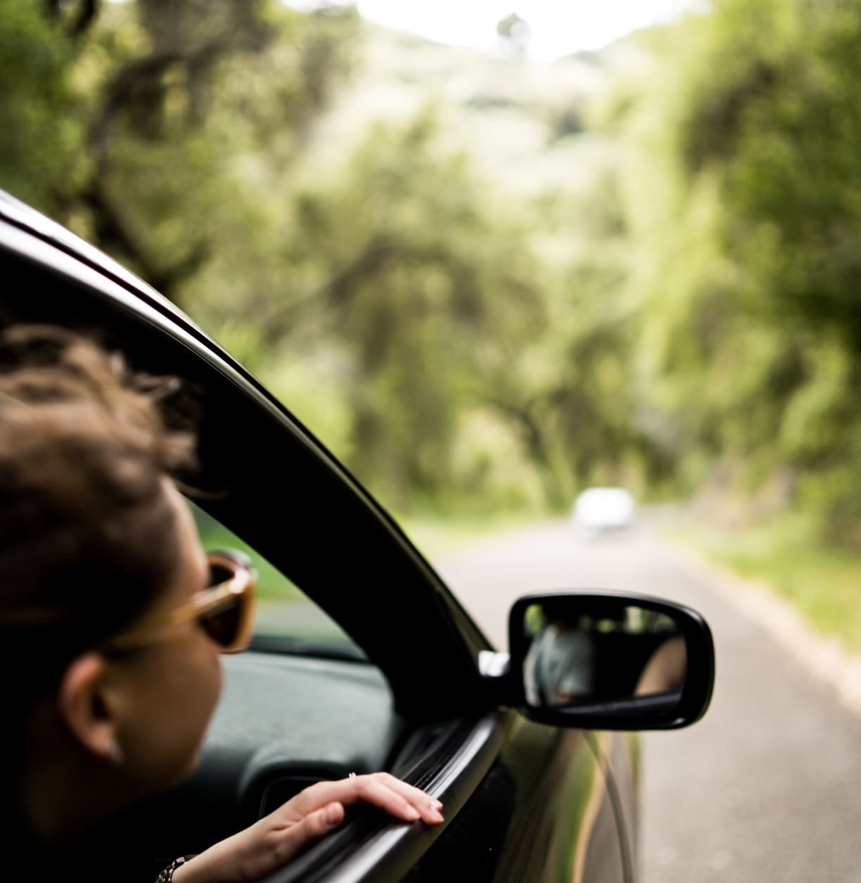 Mulher com óculos andando com um carro que alugou na Alternativacar.